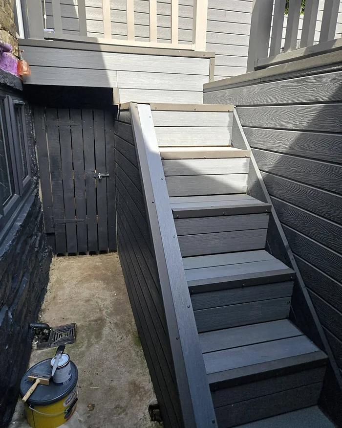 Composite steps between cladding and a dark timber gate