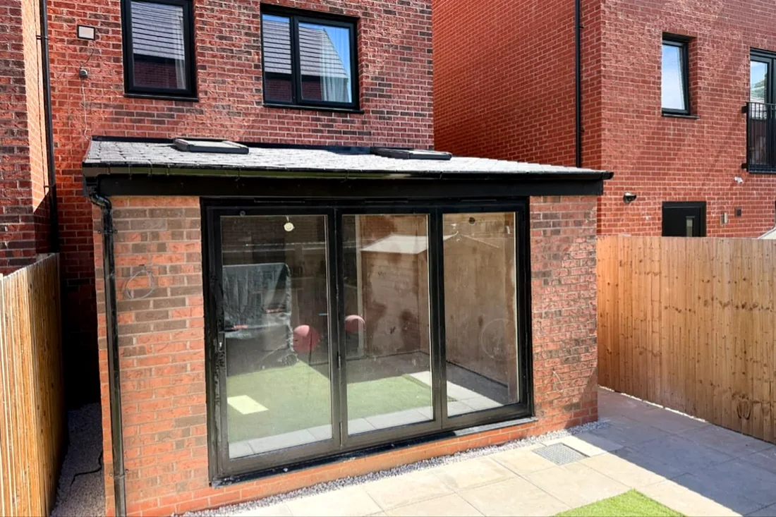 Brick rear extension with black-framed bifold doors and a slate-grey roof